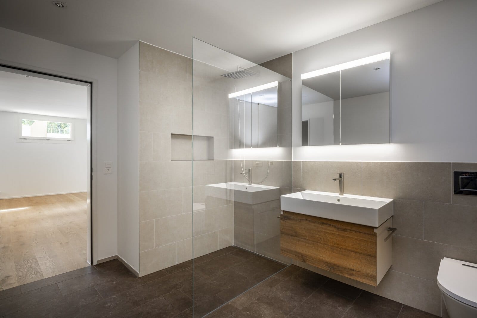 Bad mit Walk-in-Glasdusche, Wand- und Bodenplatten, Holzwaschtisch und Spiegelschränken