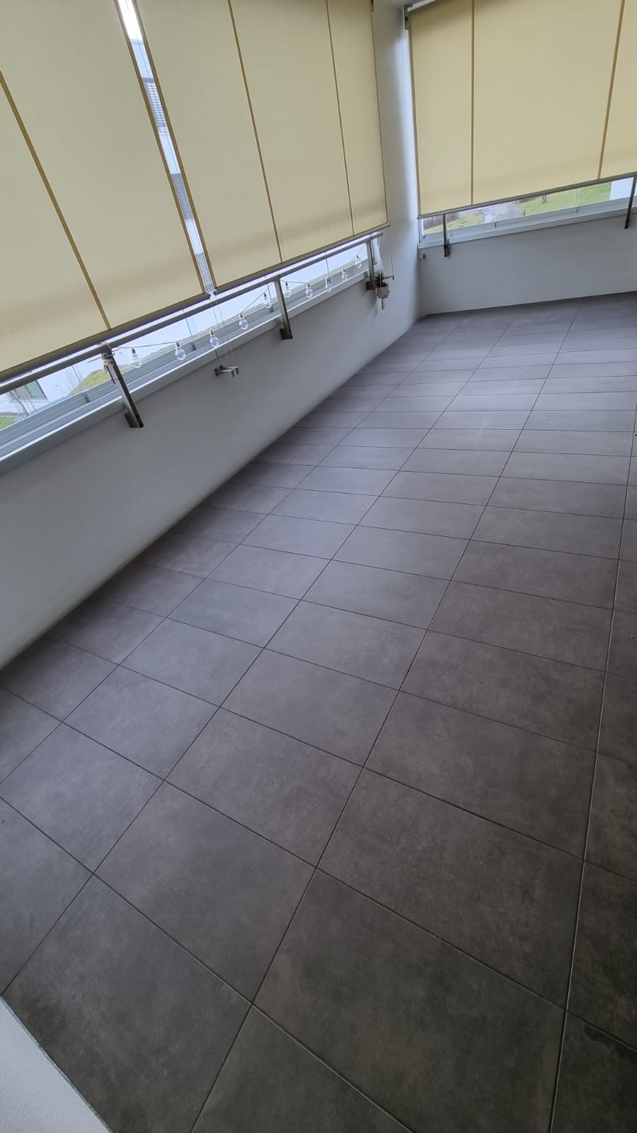 Gedeckter Balkon mit dunklen Bodenplatten